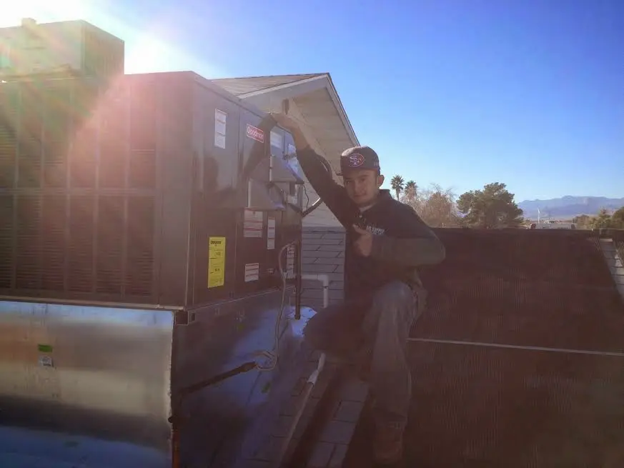 HVAC technician performing Air Duct Repair on a rooftop unit in Essex